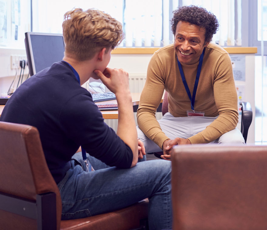 Two people in supportive conversation across a desk